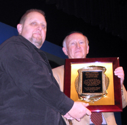 Purdue's Gary Bennett (right) presents a plaque to Greg Campbell of Hatfield Pest Control